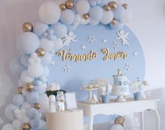 a table topped with cake and balloons next to a wall