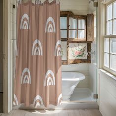 a bathroom with a shower curtain that has rainbows on it in front of a window