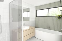 a white bath tub sitting under a window next to a sink