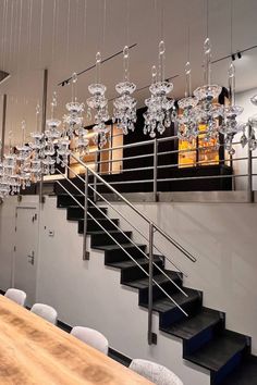 a dining room table with chairs and chandelier hanging from the ceiling