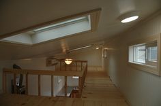 the loft is very small and has two windows on each side of the room, as well as a staircase leading up to the second floor