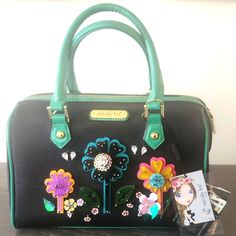 Bnwt Nicole Lee Black Preforated Duffle Bag, With Multicolor Floral Acrylic Appliques And Stone Accents. Green Patent Trim And Green Patent Trim Handles. L 12"X W 6.5"X H 13.5" With Handles Upright. Shoulder Strap Included. Never Used, No Scratches, No Tears, No Scuffs, No Stains, No Odor. New Condition! Spring Black Crossbody Satchel, Black Satchel For Spring Travel, Black Rectangular Satchel For Spring, Black Spring On-the-go Bags, Black Shoulder Bag Satchel For Spring, Black Satchel With Detachable Strap For Spring, Black Bags For Spring Errands, Nicole Lee, Floral Applique