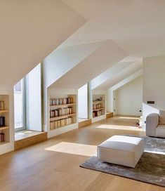 an empty living room with white furniture and bookshelves