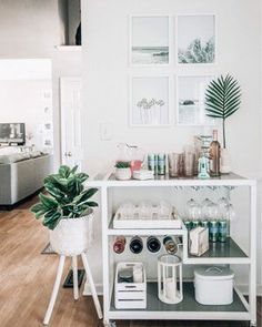 a white shelf filled with lots of items on top of a hard wood floor next to a kitchen