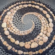 a circle made out of rocks and stones with a spiral design on it's surface