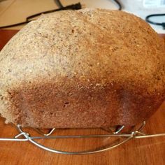 a loaf of bread sitting on top of a wooden table next to a wire rack