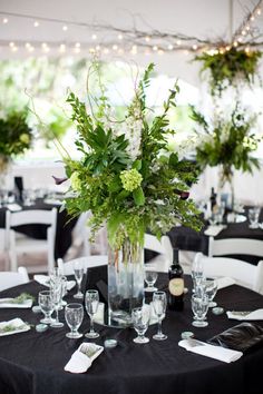 a vase filled with flowers sitting on top of a table covered in white linens