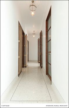 an empty hallway with two doors leading to another room and light fixture above the doorway