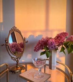 a table with flowers and a mirror on it