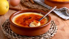 a bowl filled with soup sitting on top of a wooden table next to an egg