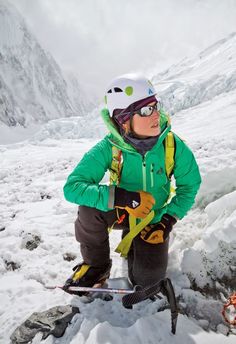 a young boy sitting on top of a snow covered mountain