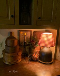 a lamp sitting on top of a wooden table next to some boxes and other items