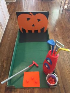 an open cardboard box filled with construction tools and pumpkins on the inside, sitting on top of a hard wood floor