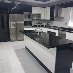 a kitchen with black and white countertops and stainless steel refrigerator freezer combos