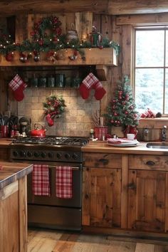 a kitchen decorated for christmas with red and green stocking hanging on the wall, stove top oven