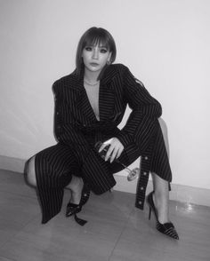 black and white photograph of a woman in pinstripe suit sitting on the floor