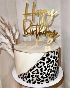 a leopard print cake with gold happy birthday topper