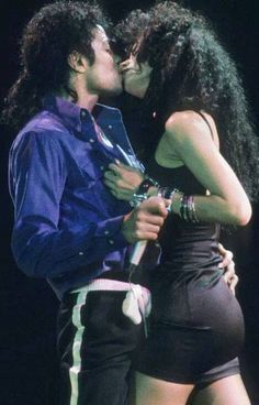 two people kissing each other on stage