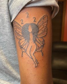 a woman's arm with a tattoo on it that has a butterfly and numbers