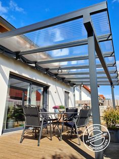 an outdoor patio with table and chairs under a pergolated roof on a sunny day