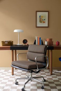 an office chair sitting on top of a checkered floor next to a desk with a lamp