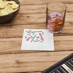 a napkin with the word genny on it next to a bowl of chips and a drink