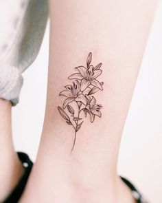 a black and white photo of a flower tattoo on the right side of the leg