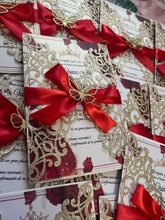 many red and gold wedding cards with bows on the front are laid out next to each other