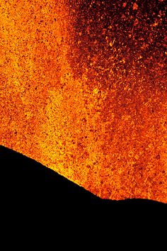 the silhouette of a person standing in front of an orange and black background with lots of dust