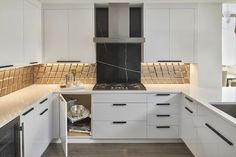 a kitchen with white cabinets and black appliances