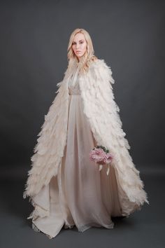 "Luxurious ivory ostrich feather plume cape inspired by Swan Lake. 100% real feathers hand applied to the base fabric. Cape is fully lined and has a double sided satin ribbon for tying a bow. Perfect for your wedding or any other special occasion. Please specify size by supplying measurements of height and circumference around shoulders and neck. Product shown in size small, ivory feathers with an extra length of 8\". These feathers are a light ivory to champagne color depending on the type of l Feather Cloak, Feather Clothes, Angelic Style, Tying A Bow, Feather Outfit, Feather Cape, Feather Gown, Feather Coat, Swan Dress