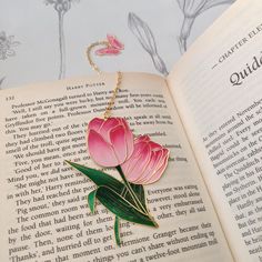 an open book with pink flowers on it