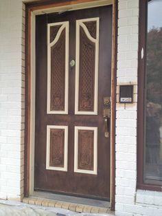 a dog is standing in front of the door to a house that has been painted white and brown