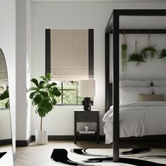 a bedroom with a bed, mirror and potted plant in the corner on the floor