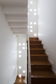 the stairs are made of wood and have white walls