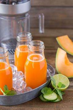 three glasses of orange juice with ice and sliced melon