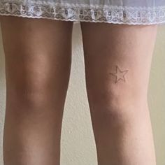 a woman's thigh with a small star tattoo on it