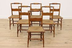 six wooden chairs with cane back and seat cushions, all in different positions on the floor