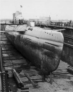 an old submarine sitting on top of a dock