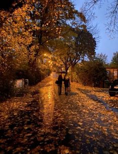 two people walking down the street in the rain with umbrellas over their heads and one person holding an umbrella