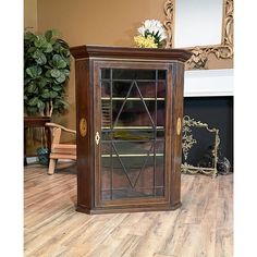 an old wooden cabinet with glass doors on the front and sides, in a living room