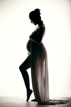 a pregnant woman is posing for a black and white photo with her leg up in the air