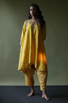 Mango yellow kurta with gota, thread and sequin embroidered neckline and an asymmetric hem. Paired with a bandhani dhoti pant and dupatta.
Components: 3
Pattern: Embroidered
Type Of Work: Hand embroidery
Neckline: Round
Sleeve Type: Three-quarter
Fabric: Silk
Color: Yellow
Other Details: 
Attached lining
Approx. product weight: 700 gms
Length:
Kurta: 38 inches
Dhoti Pant: 40 inches
Closure:
Dhoti Pant: Elastic
Occasion: Mehendi and Haldi - Aza Fashions Yellow Salwar Kameez With Chikankari Embroidery For Transitional Season, Transitional Season Yellow Salwar Kameez With Chikankari Embroidery, Transitional Yellow Chikankari Embroidery Salwar Kameez, Traditional Yellow Salwar Kameez For Transitional Season, Traditional Yellow Salwar Kameez, Bollywood Style Salwar Kameez For Rituals, Traditional Bollywood Salwar Kameez For Rituals, Traditional Drape Salwar Kameez For Navratri Rituals, Navratri Salwar Kameez For Rituals With Traditional Drape