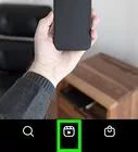 a person holding up a cell phone in front of a table with a wooden box on it