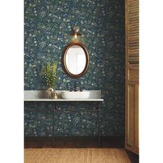 a bathroom sink sitting under a mirror next to a wall mounted faucet in front of a wooden door