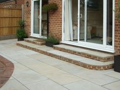 a brick house with white windows and steps