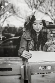 a woman sitting at a table with a piece of paper in her hand and looking down