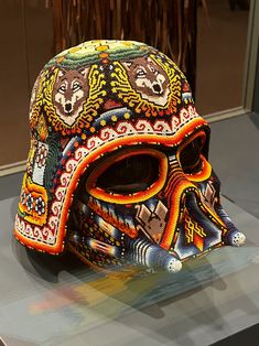 a colorful helmet is on display in a glass case with other items around the perimeter