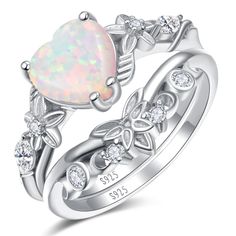 an opal heart shaped ring with leaves and diamonds on the sides, set in white gold