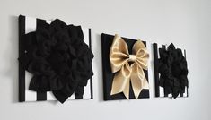 three black and gold bows are hanging on the wall